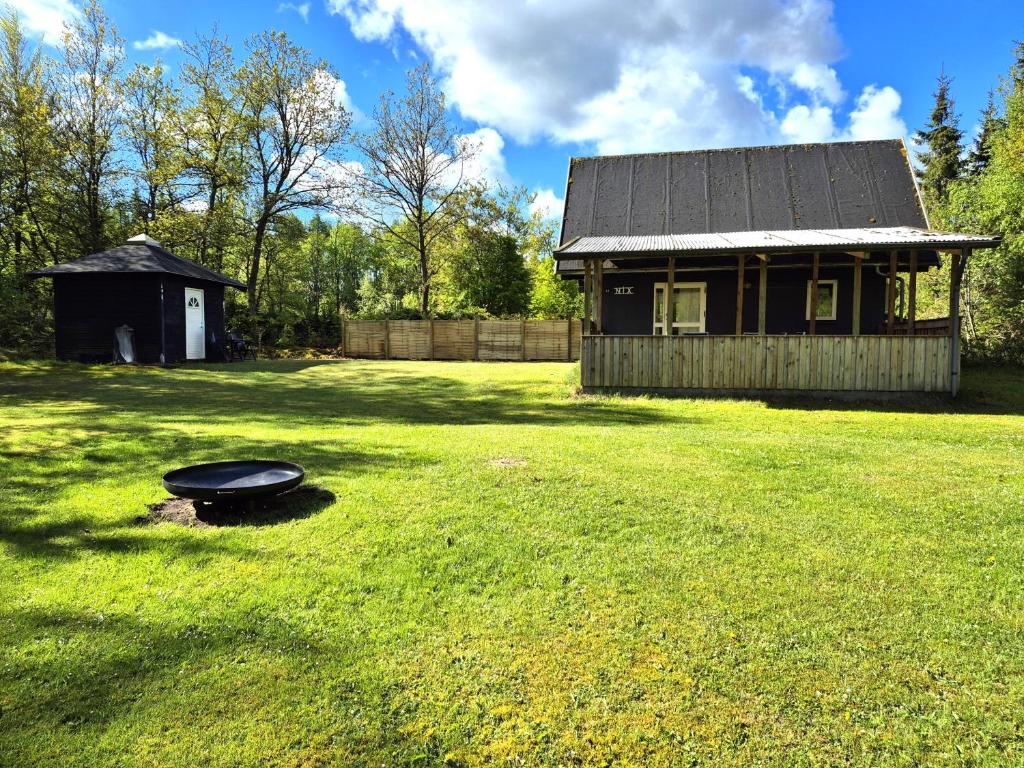 a house in a yard with a frisbee in the grass at Nix at Gammel Rye in Ry