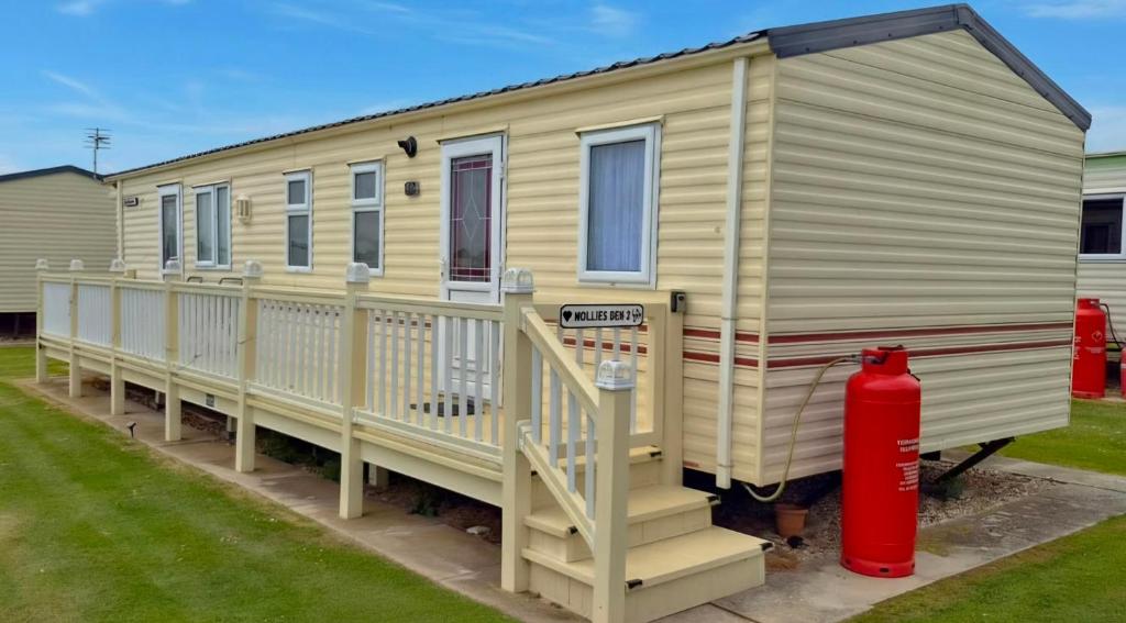 a yellow house with a red fire hydrant next to it at MOLLIES DEN 2 8 Berth 3 Bedrooms The Grange Holiday Park INGOLDMELLS in Ingoldmells