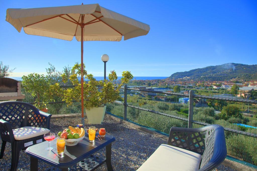 a table with a bowl of fruit and an umbrella at Casa Ilaria in Diano Marina
