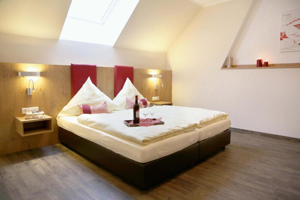 Schlafzimmer mit einem großen Bett mit einem roten Kopfteil in der Unterkunft Wasmayr Hof in Landshut