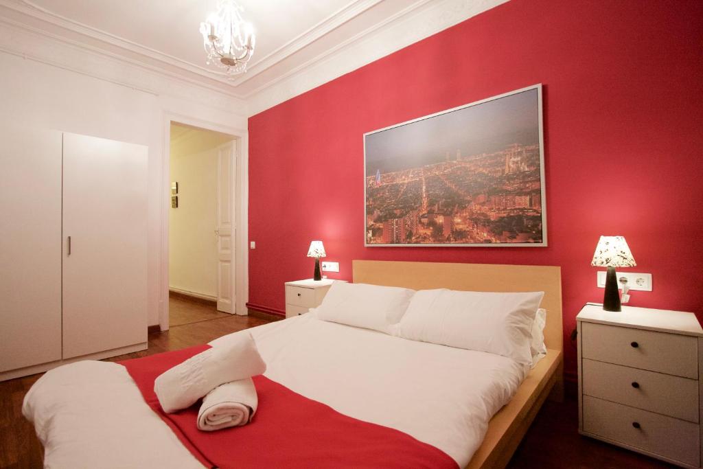 - une chambre avec un grand lit et un mur rouge dans l'établissement Charm Rambla Catalunya, à Barcelone