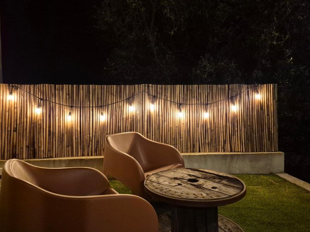 a patio with two chairs and a table and lights at Chambre Lavighiu in Patrimonio
