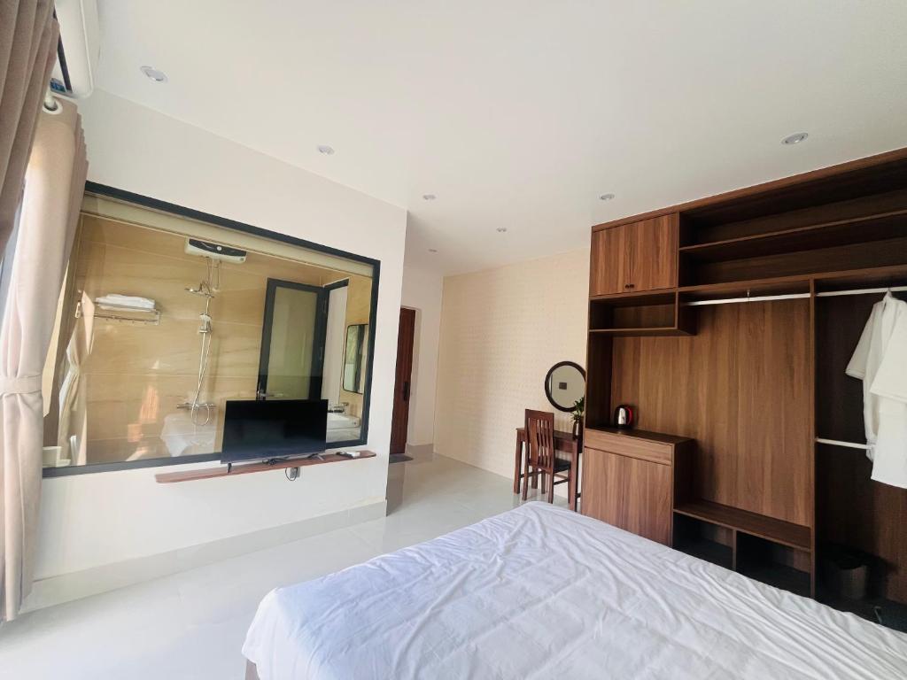 a bedroom with a bed and a large window at An Haven Villa in Phú Xá