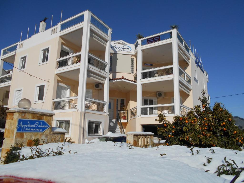 a large white building with snow in front of it at Argoliki Thalassa in Myloi