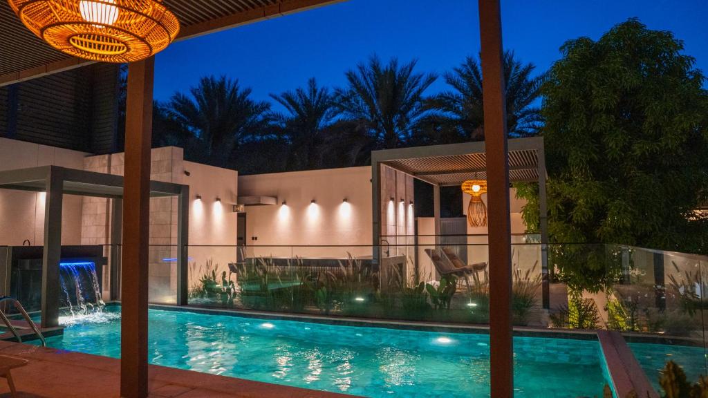 a house with a swimming pool at night at Bustan Alsafia بستان الصافية in Nizwa