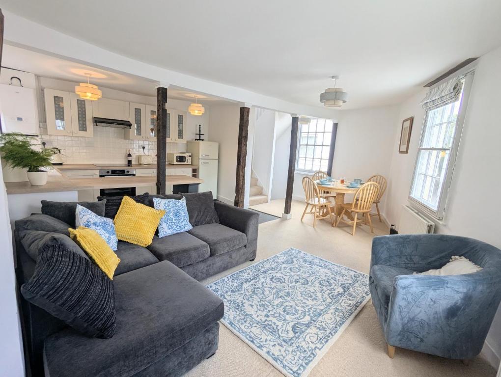 a living room with a couch and two chairs at Historic maisonette cottage in Cuckfield
