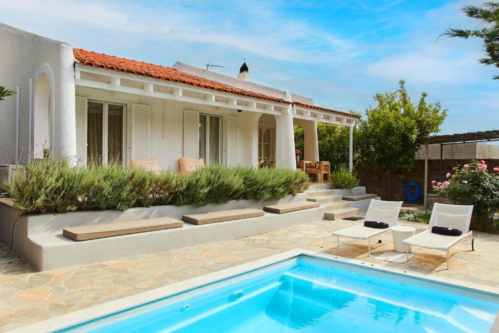 a house with a swimming pool in front of a house at Villa NS in Perdika