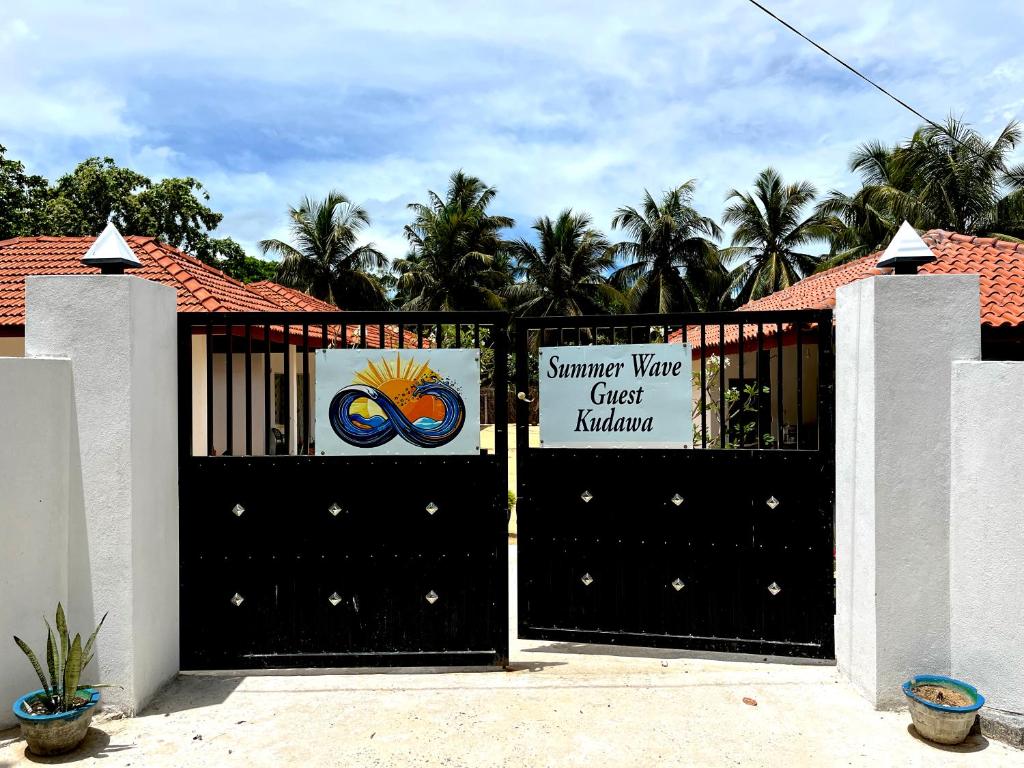 a black gate with a sign in front of a house at Summer wave kudawa and Kite surfing school in Kalpitiya