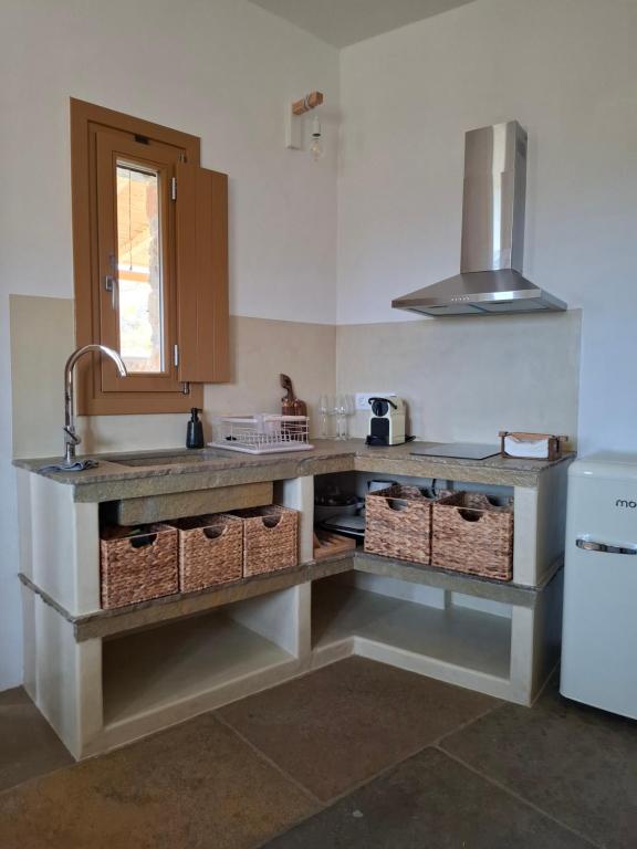 a kitchen with a sink and a counter with baskets at ACHERONAS Residences in Serifos Chora