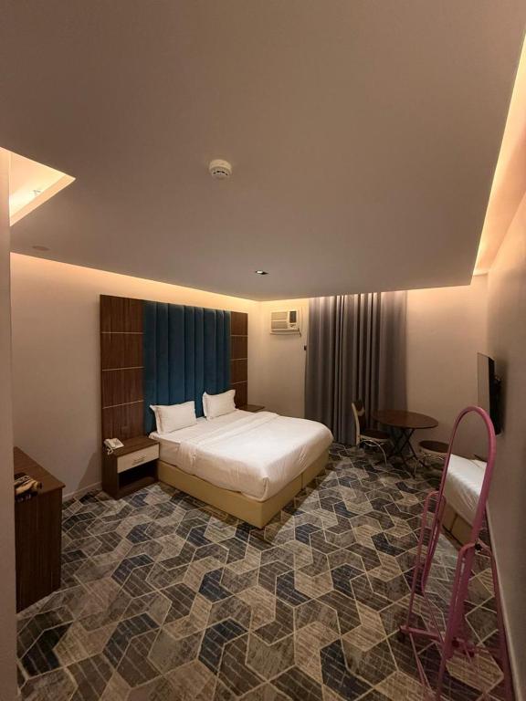 a bedroom with a bed and a desk and a chair at كيان الين الشبلان - KAYAN ALYN AlMansak Suites in Abha