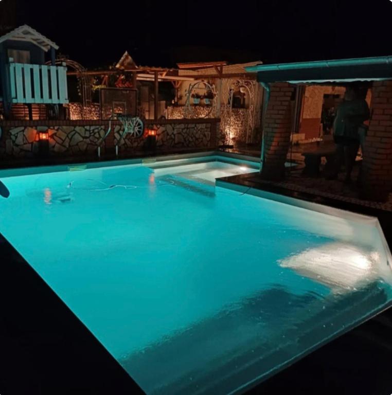 ein nachts beleuchtetes Schwimmbad in der Unterkunft Pooloase in Colbitz