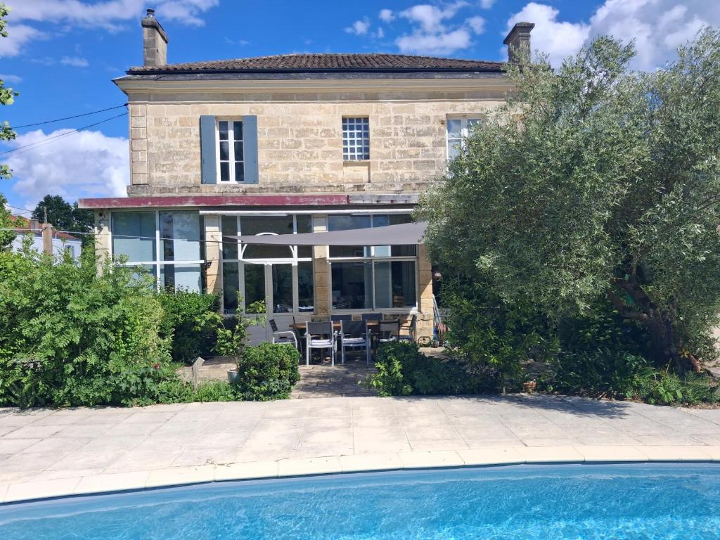 a house with a pool in front of it at L'entre deux M in Saint-Loubès