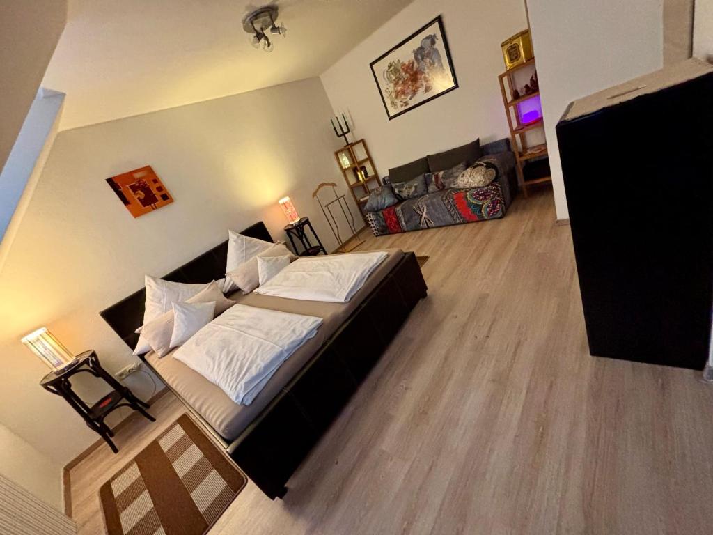 a bedroom with a large bed with white pillows at Bright studio-flat near station - Bayreuth in Bayreuth