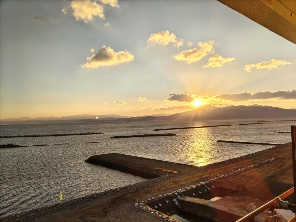 a view of the sun setting over the water at 指宿 潮音 Ibusuki Shione in Ibusuki