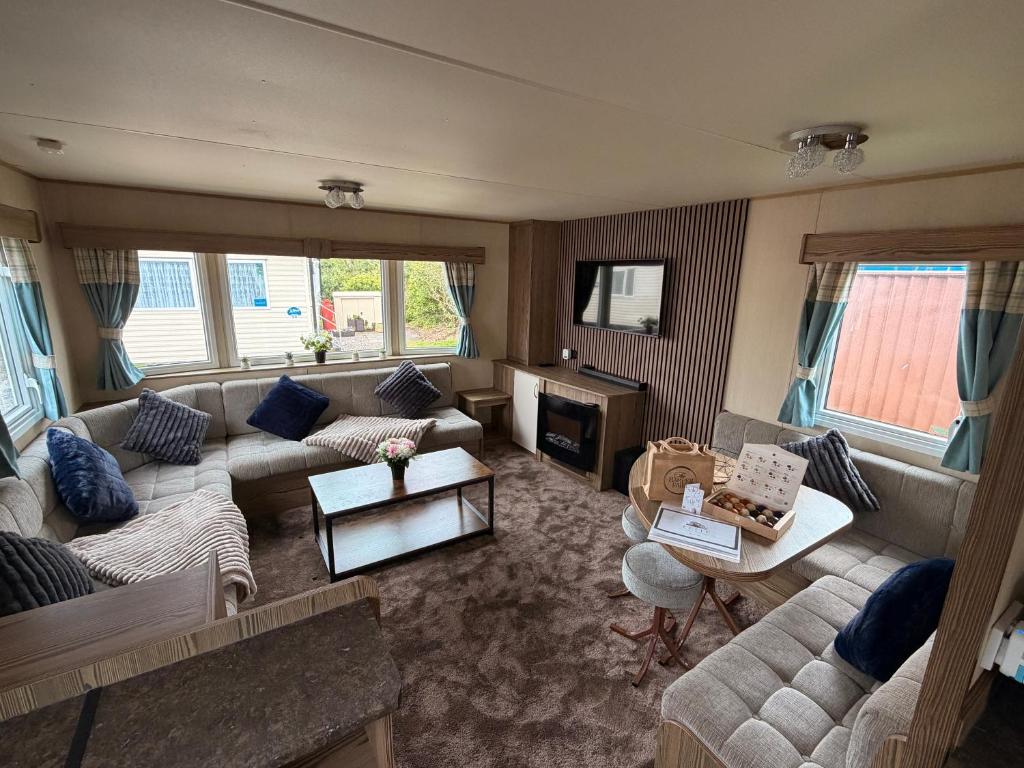 a large living room with couches and a table at Elite Retreat Caravan in Blackpool