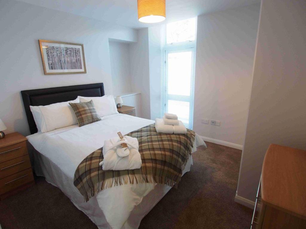 a bedroom with a bed with towels on it at APL Apartments in Aberdeen