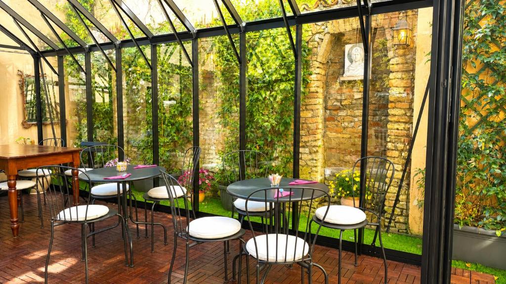 a restaurant with tables and chairs in a greenhouse at Al Battistero Luxury Suite in Ravenna
