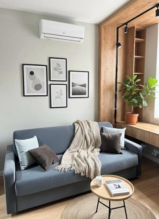 a living room with a blue couch and a table at Cathedral Park Modern studio in Chişinău