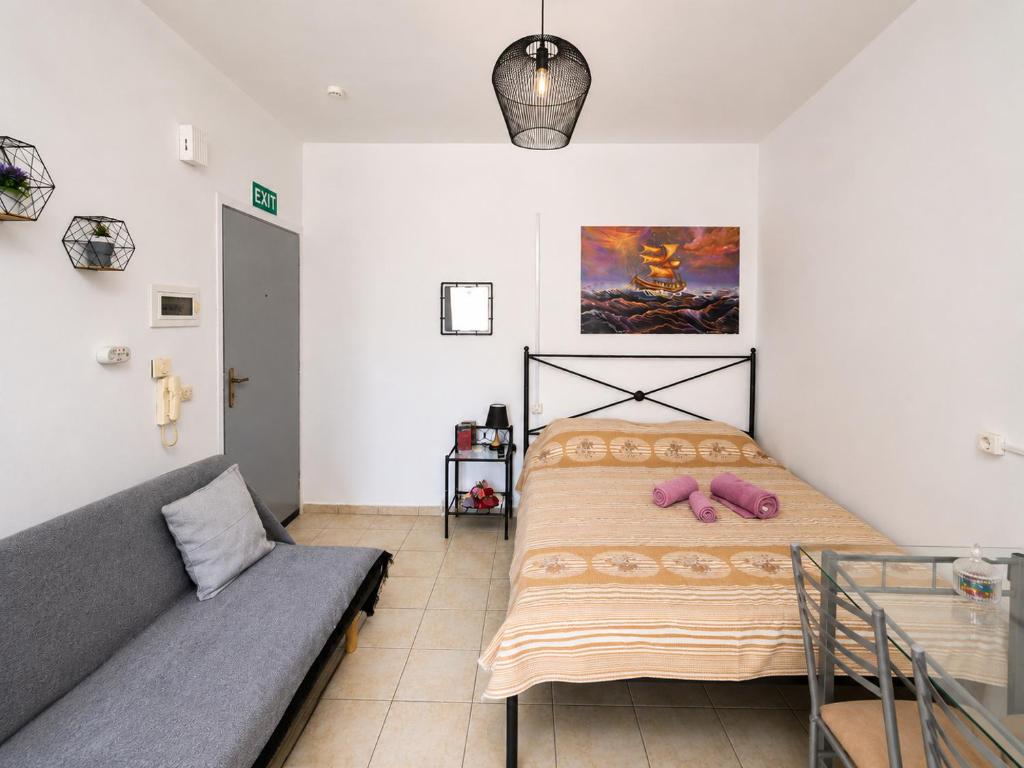 a bedroom with a bed and a couch at University Apartment in Heraklio