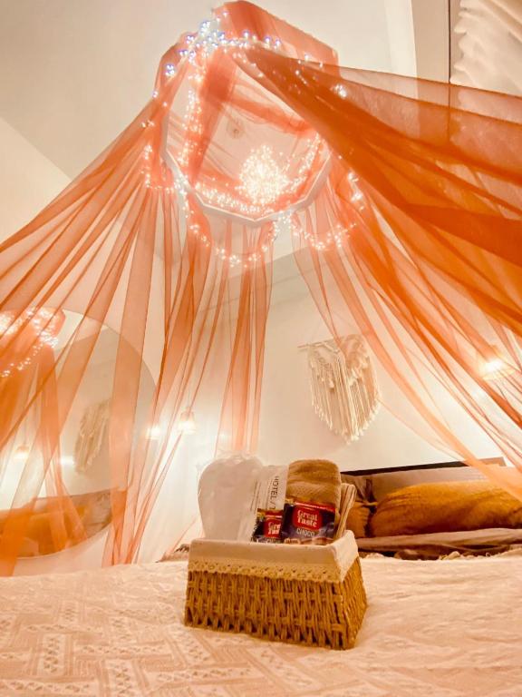 a bed with a canopy with a basket of food on it at Hiraya Luna in Manila