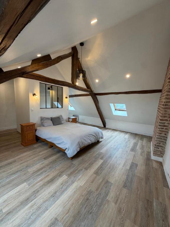 a bedroom with a large bed and wooden floors at Maison de bourg de village in Dame-Marie-les-Bois