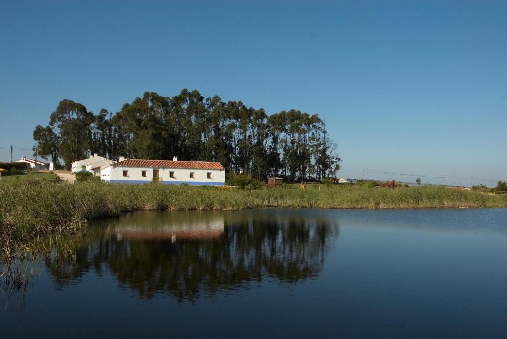 a house sitting next to a body of water at Cerro Da Fontinha in São Teotónio