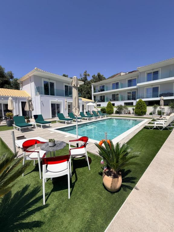 a patio with a table and chairs next to a swimming pool at Sueño Suites in Parga