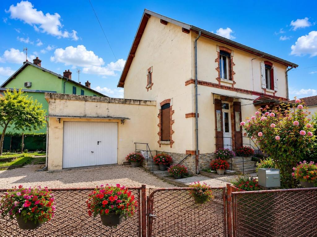 an old house with a garage in front of it at Entre Rails & Rives in Montbard