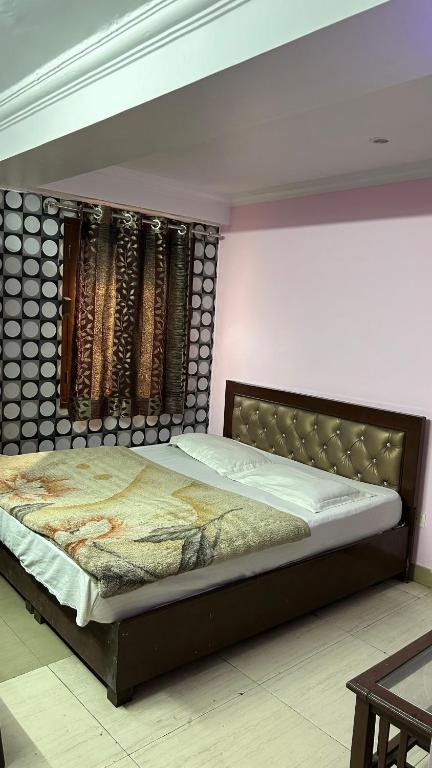 a bedroom with a large bed with a wooden headboard at BS Residency in Dehradun