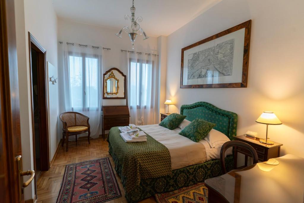 a bedroom with a bed and a table and a chair at Locanda Confini in Dolo