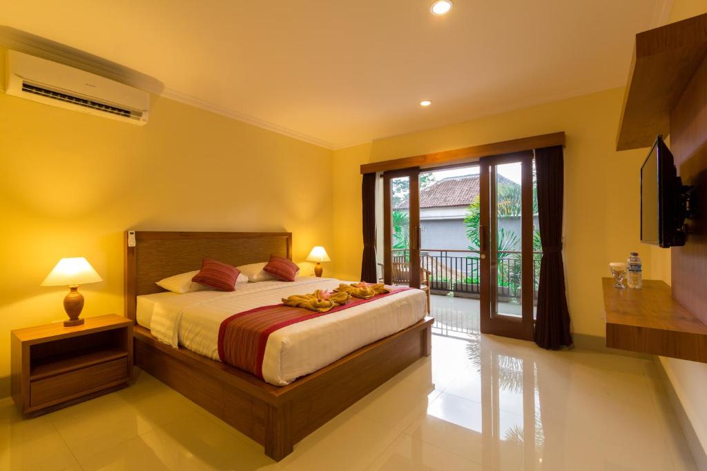 a bedroom with a bed and a large window at Krisna House in Ubud