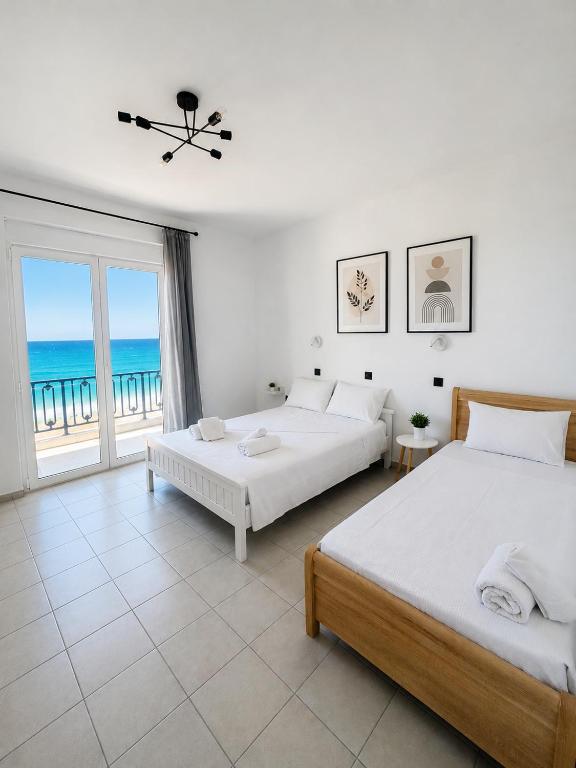 a bedroom with two beds and a view of the ocean at Oceanica k rooms in Loutsa