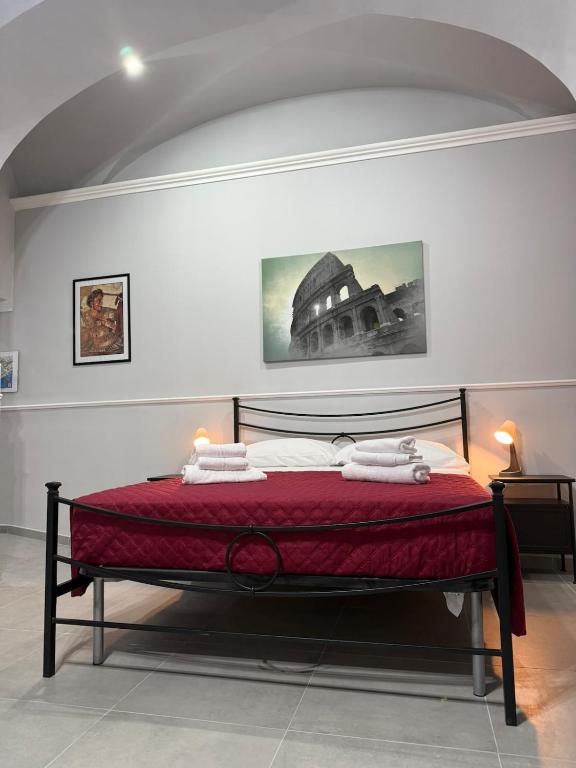 a bedroom with a bed with red sheets and towels at CENTURIONI Alloggio turistico in Civitavecchia