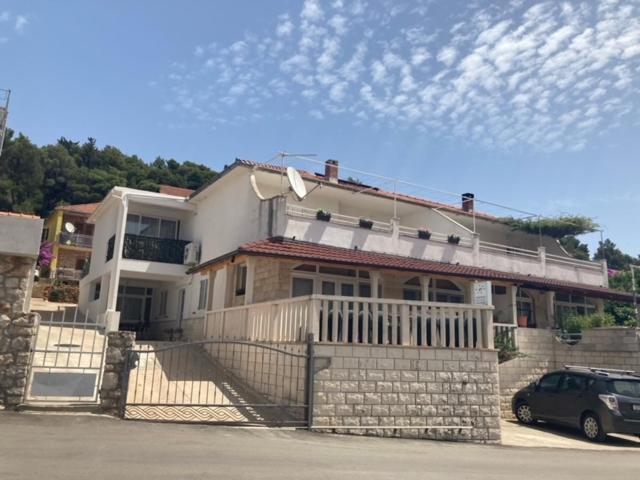 a house with a car parked in front of it at Apartmani Vinko Palaversić in Jelsa