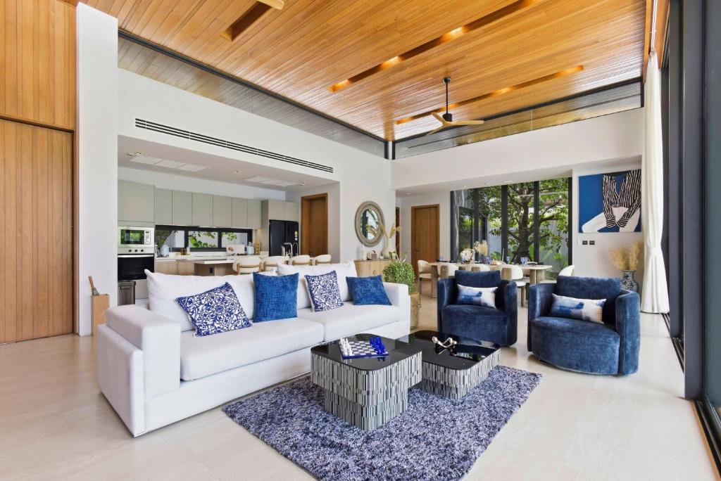a living room with a white couch and blue chairs at Botanica Foresta Luxury Villa Phuket in Phuket