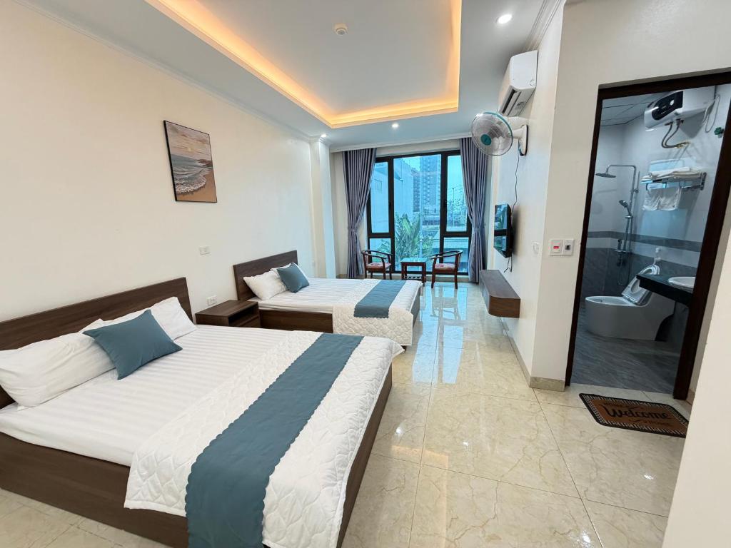 a hotel room with two beds and a bathroom at Hiếu Thảo Hotel & Restaurant in Lôc Hải