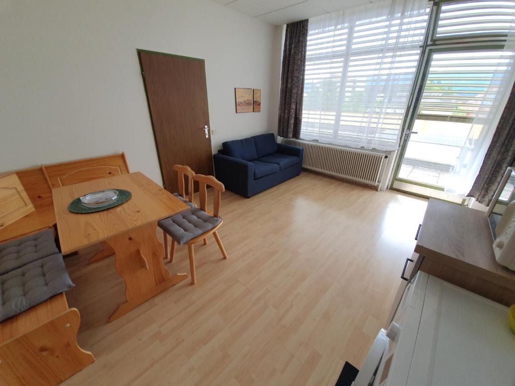 a living room with a table and a blue couch at Grössingblick in Zeltweg