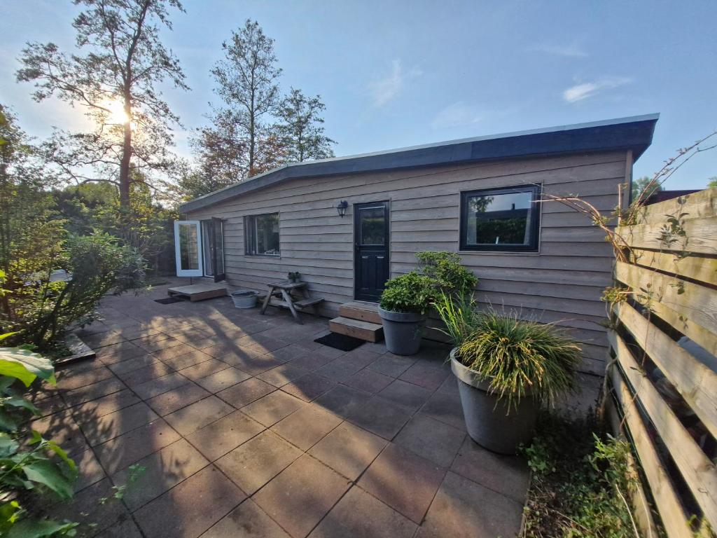 a small house with a patio with plants at Nieuw chalet in Nunspeet in Nunspeet