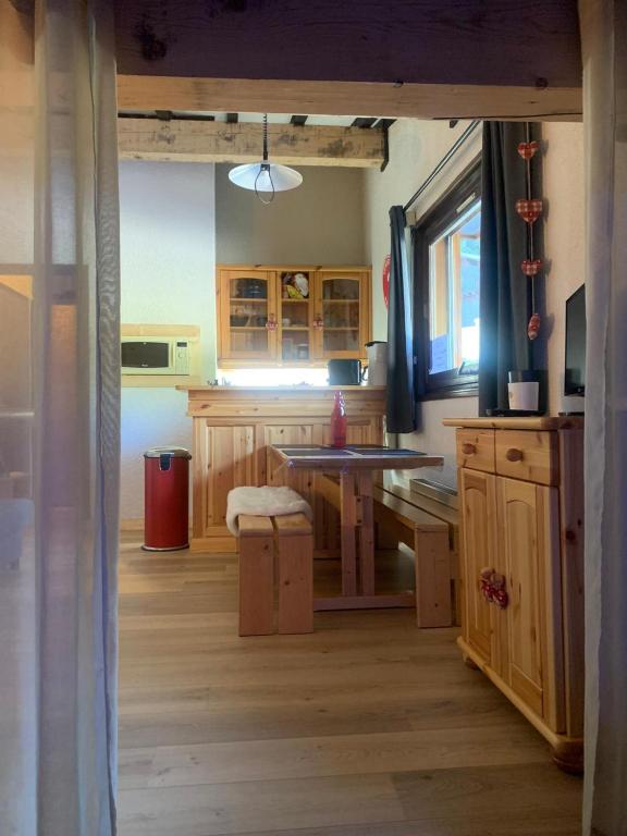 a kitchen with wooden cabinets and a wooden floor at Bouquetin studio cosy in Notre-Dame-de-Bellecombe