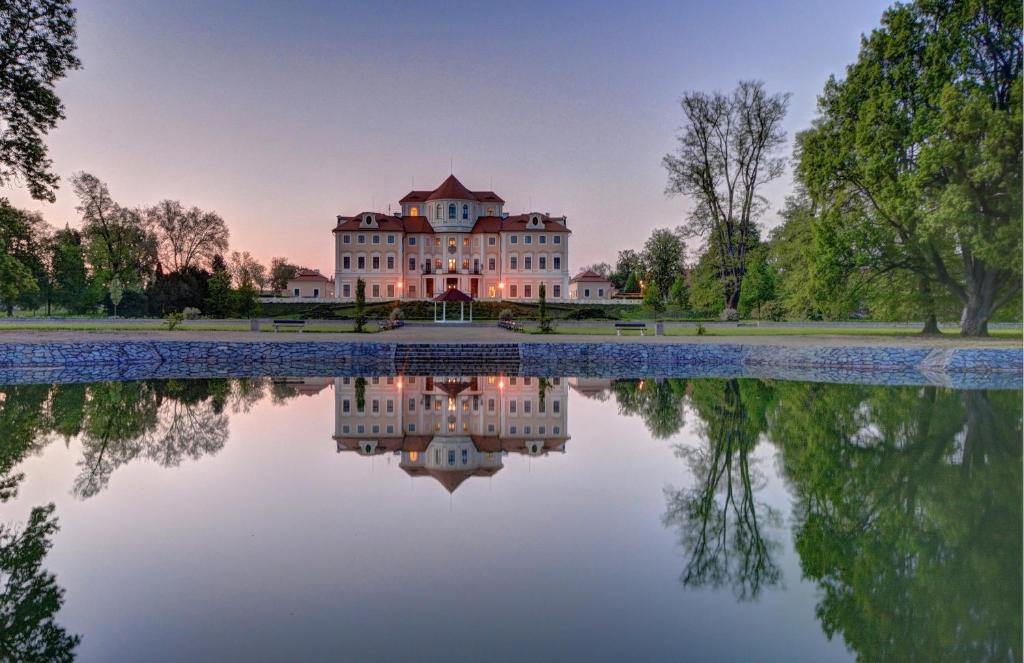 una imagen de un edificio con un reflejo en el agua en Château Liblice, en Byšice