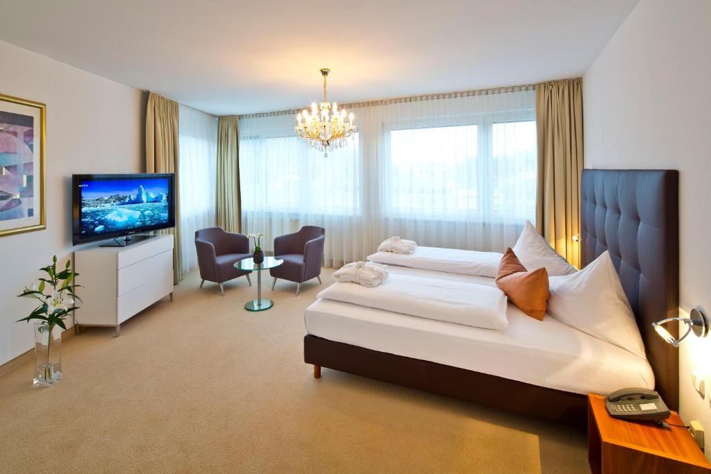 a hotel room with a bed and a flat screen tv at Hotel Penz West in Innsbruck