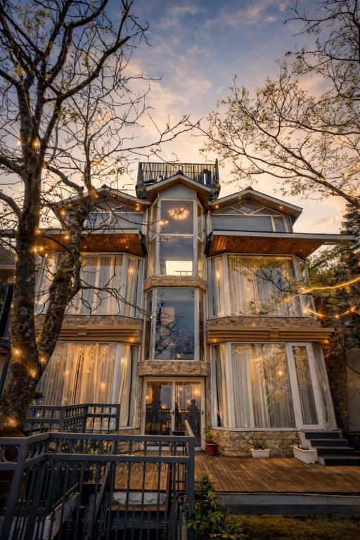 a large house with curtains on the front of it at Oak Villa in Dharampur