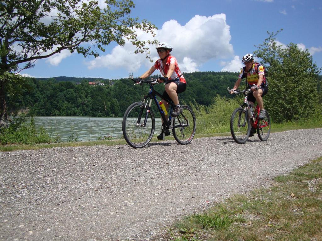 due persone che vanno in bicicletta su una strada sterrata vicino a un lago di Ferienwohnung Mostecky a Ferlach