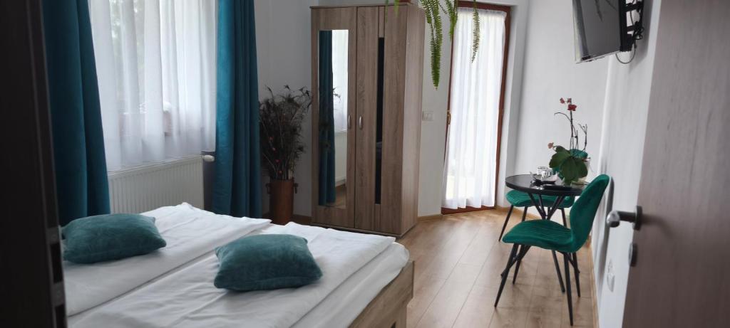 a bedroom with a bed with blue pillows and a table at Casa Maria in Avrig