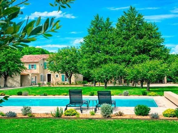 two chairs sitting in front of a swimming pool at Mas Guerite - Provence in Aubignan