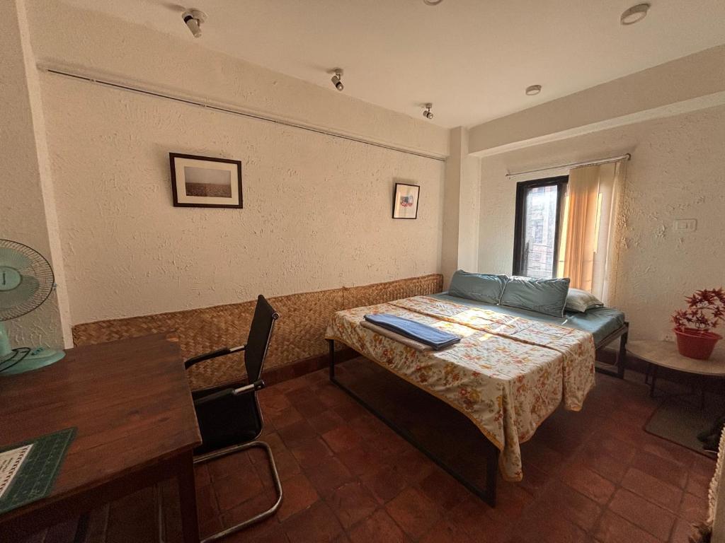 a room with a bed and a table and a couch at Davu Gallery Cafe in Kathmandu