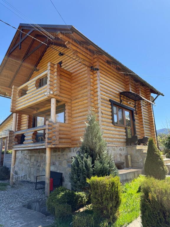 a log cabin with a porch on the side of it at Beauty House in Mykulychyn