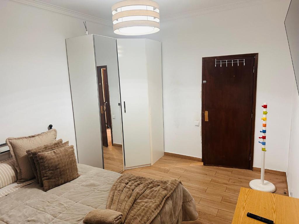 a living room with a bed and a mirror at Casa Paz in Alcabideche