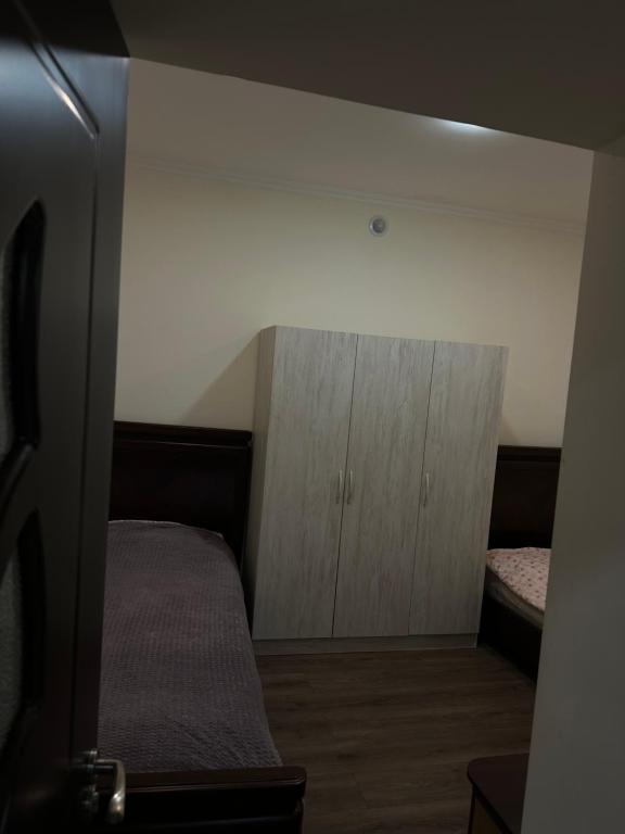 a bedroom with a bed and wooden cabinets in a room at Happy Holidays in Yerevan