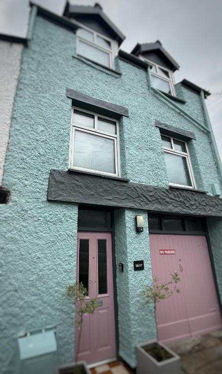a blue house with two pink doors and windows at Buxton Mews in Ulverston
